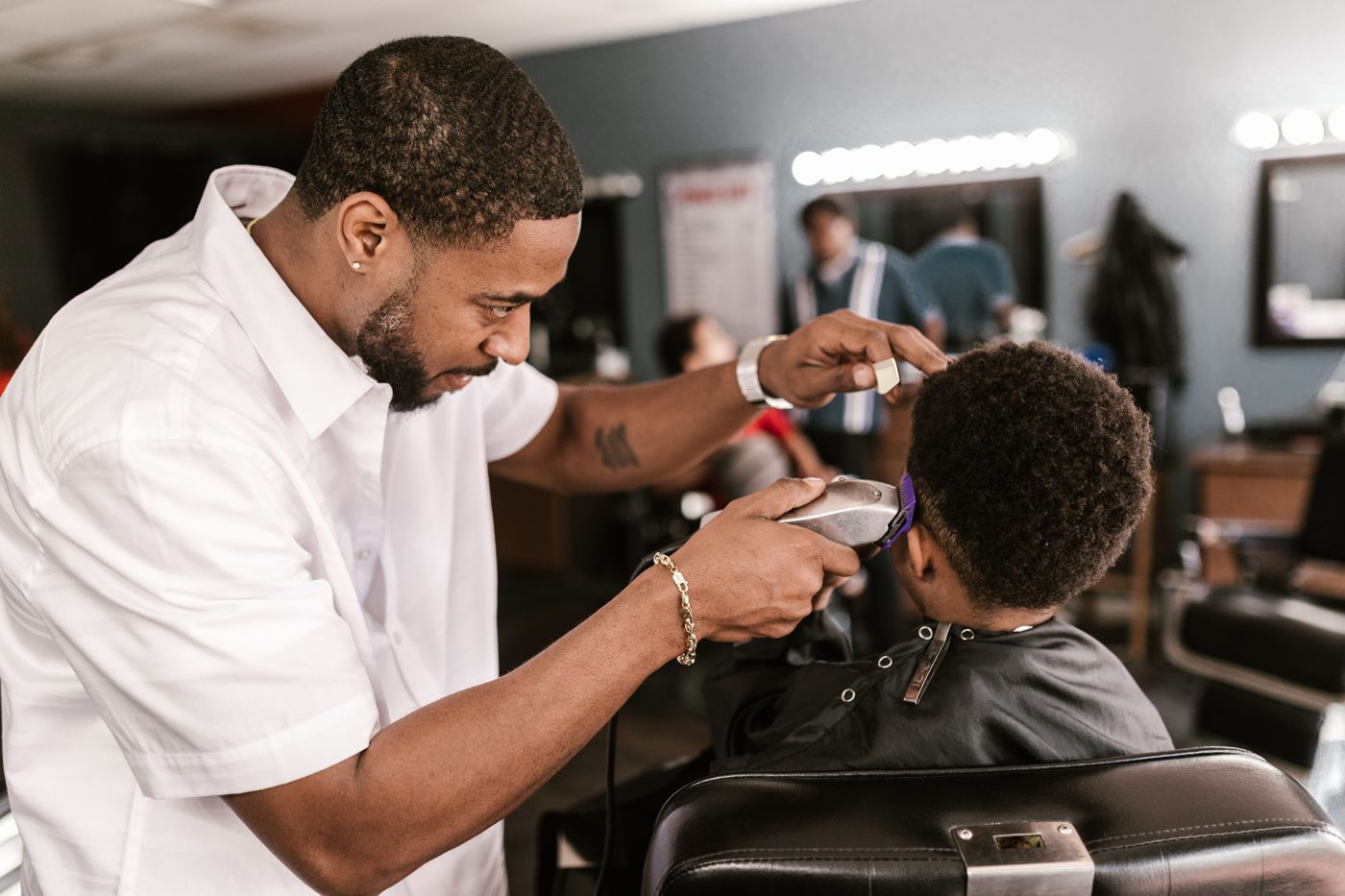 A barber cutting a young client's hair